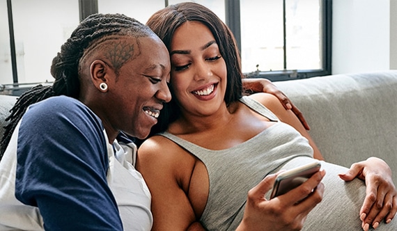 couple messaging their doula on their phone