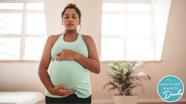 Pregnant woman holding her belly with eyes closed