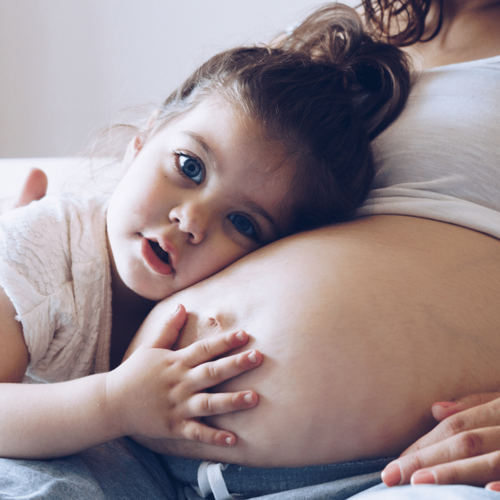 little girl hugging pregnant belly
