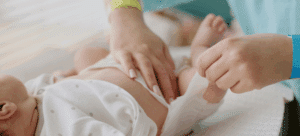 New mom learning to change her newborn's diaper