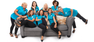 Group of Helping Hands Doula team members taking a photo on a grey couch