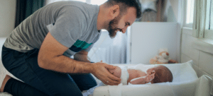 dad changing diaper at home natural light